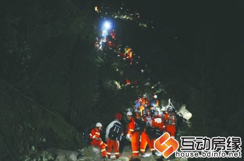 21日凌晨，消防救援队员借助电筒的微弱灯光，穿过通往宝兴县的一处滑坡地带