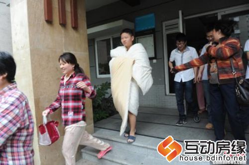图为成都民众从睡梦中惊醒，逃离住宅大楼。