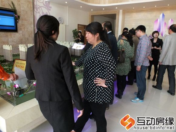 客户聚集在沙盘前看小区规划