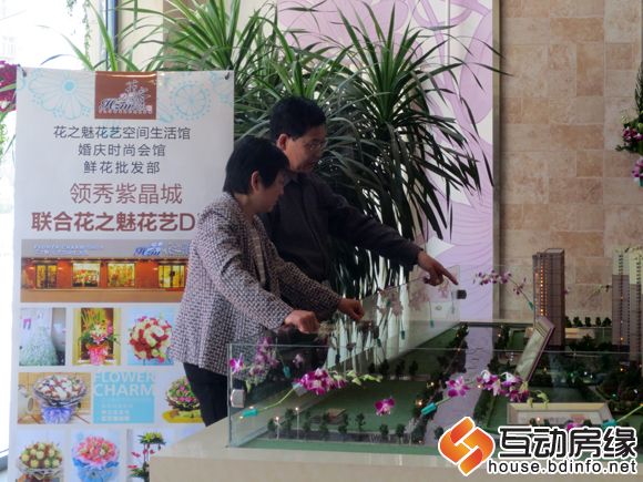 老两口在看自己家买的那栋楼的沙盘