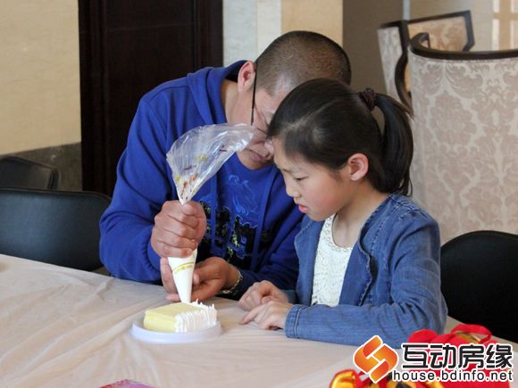 图为小朋友在父亲的帮助下制作蛋糕