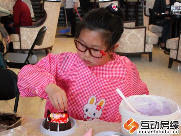 图为小朋友为成形蛋糕添加装饰