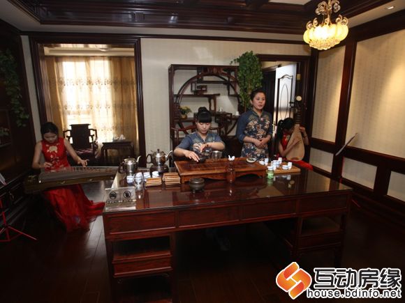 图为国宅大户型样板间内，“飘雪”正在为客户们演奏乐曲、表演茶艺