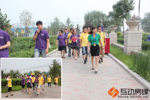 图为哈罗城工作人员带领业主参观园林景观及样板间的路上