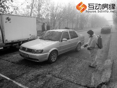 防疫人员正持消毒器对出入封锁区的运输车辆喷洒消毒液供图/韩楠