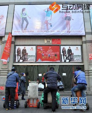 12月25日，动物园附近一处批发市场外，几位拉货的工人正在等生意。记者从北京市规划委获悉，达人“淘衣圣地”北京动物园批发市场已确定外迁，目前正在进行选址，尚未确定迁至市郊还是河北，原址将进行产业升级转型。（新华社记者 李文摄）