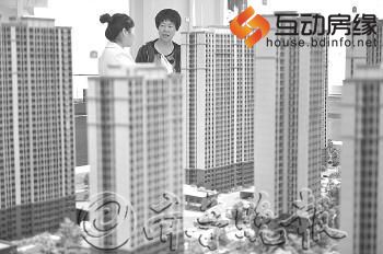 济南某楼盘,一售楼小姐向顾客介绍楼盘。（图片来源：齐鲁晚报 王媛 摄）