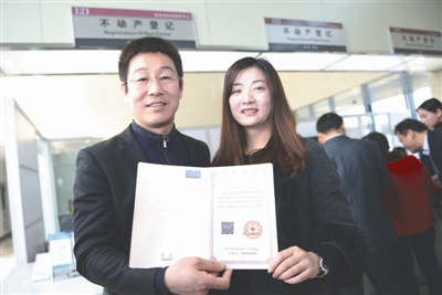 3月1日，在江苏徐州市不动产登记交易服务中心，市民邢卫锋、赵媛媛夫妇在展示编号为001的不动产权证书。当日，《不动产登记暂行条例》开始施行。国土资源部部长姜大明在江苏徐州市为申请领证的市民颁发了全国第一本不动产权证书。新华社发