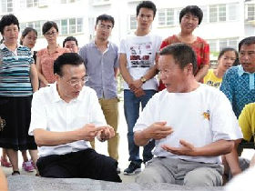 李克强与进城农民掰手指数城镇化好处