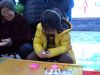 小朋友认真的比对着图片捏软陶